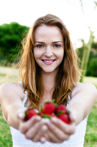beautiful smiling woman in garden with strawberries - Fotó, kép