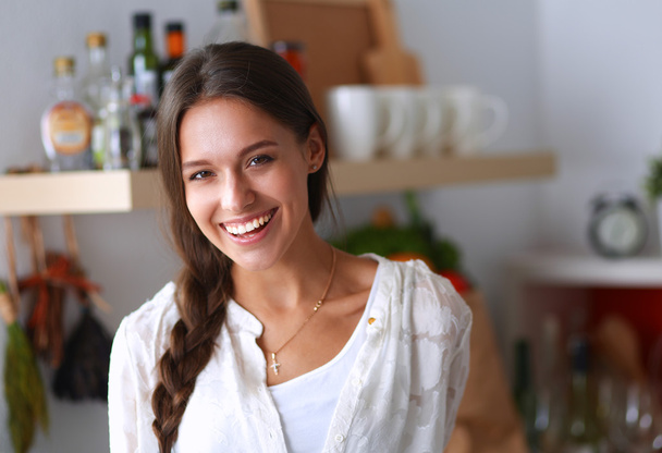 Young woman standing near desk in the kitchen - Photo, image