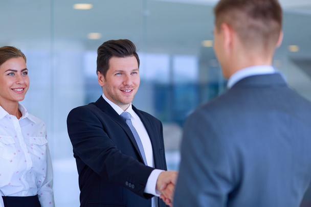 Two successful business men shaking hands with each other - Foto, afbeelding