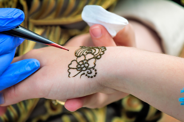 Un tatoueur applique son métier sur la main d'une femme
 - Photo, image