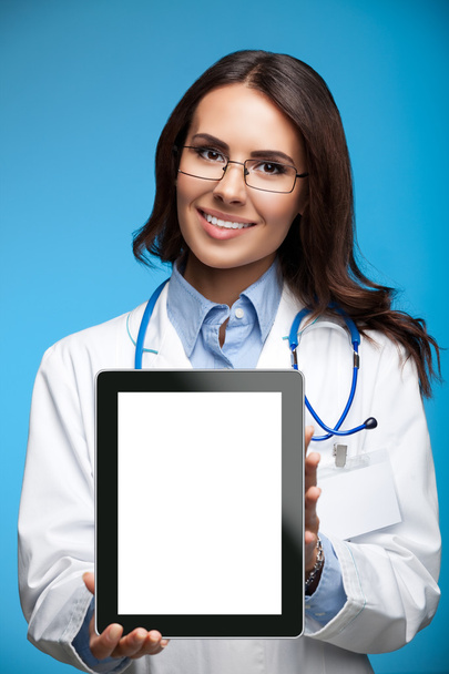 Doctor showing blank tablet pc for copyspace, on blue - Foto, Imagen