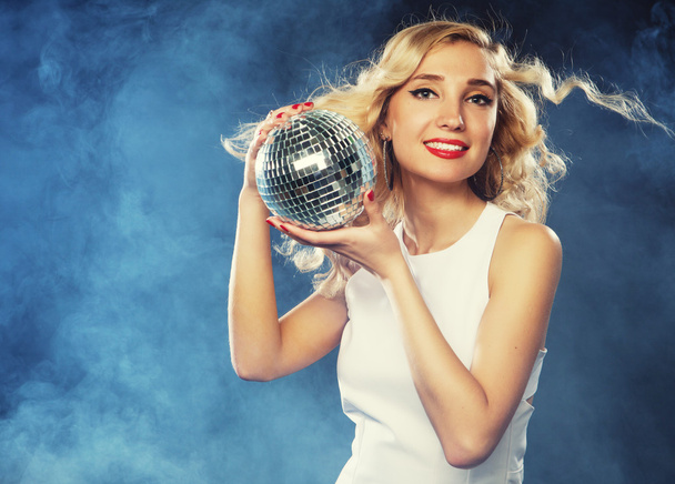 Beautiful young woman holding disco ball at night club - Foto, Imagen
