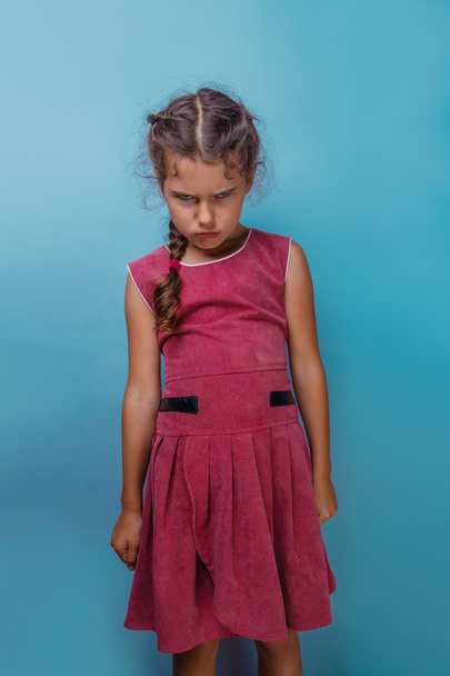 Mädchen europäisches Aussehen Jahrzehnt wütende Stirnrunzeln auf blauem Hintergrund - Foto, Bild
