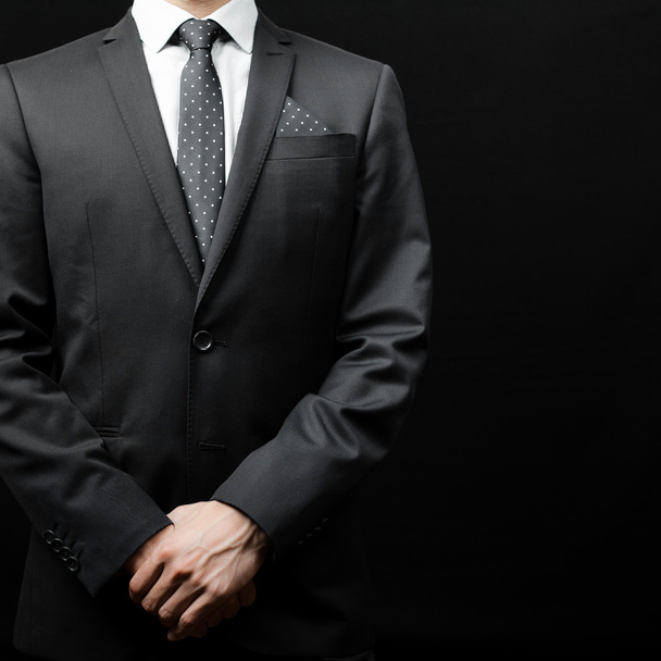 man in suit on a black background - 写真・画像
