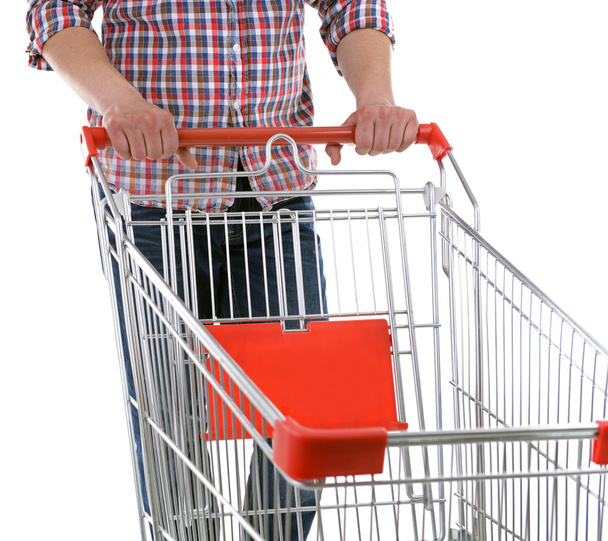 Young man with empty shopping cart isolated on white - Foto, Bild