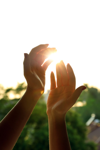 Жіночі руки над фоном неба заходу сонця
 - Фото, зображення