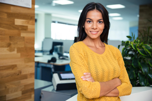 Businesswoman standing with arms folded in office - Photo, Image