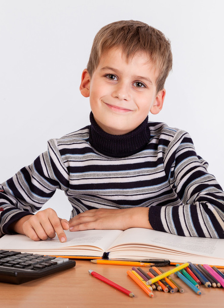 Cute schoolboy is writting - Photo, image