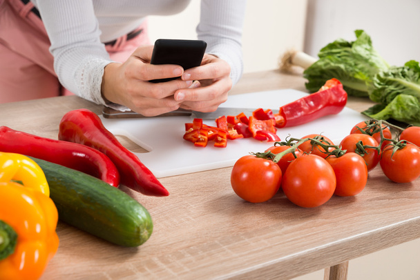 Woman With Mobile Phone And Vegetables - Фото, изображение