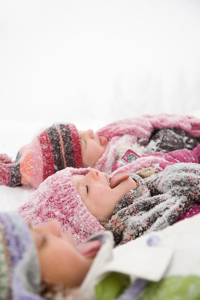 Niños en la nieve sacando la lengua
 - Foto, Imagen