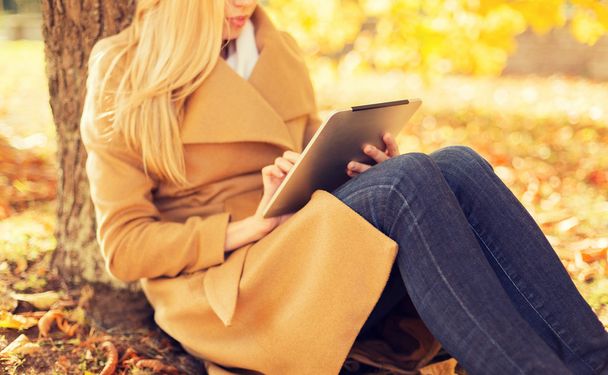 young woman with tablet pc in autumn park - Foto, immagini
