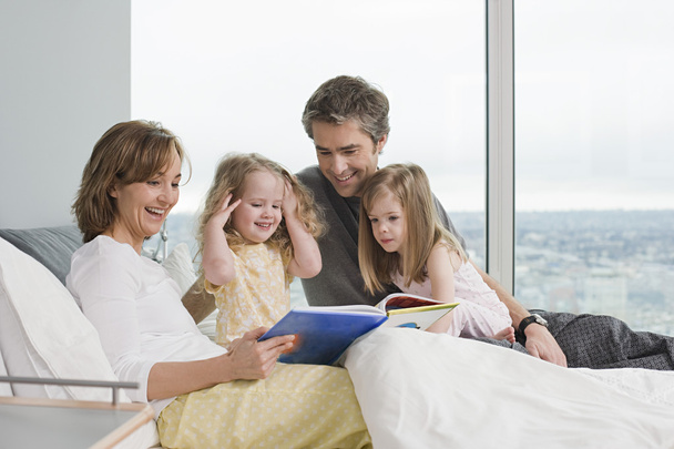Família lendo um livro
 - Foto, Imagem
