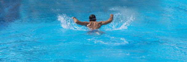 Homem nadando na piscina sozinho.Estilo borboleta. Férias
. - Foto, Imagem