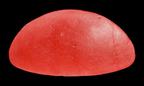 One red Swedish candy isolated on black background - Photo, Image