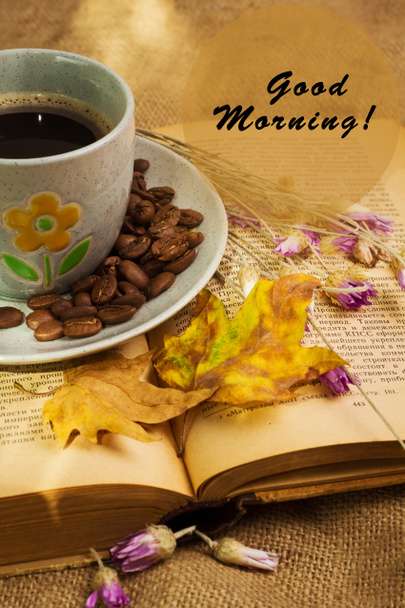 De kop koffie liegen ot het geopende boek met esdoorn bladeren - Foto, afbeelding