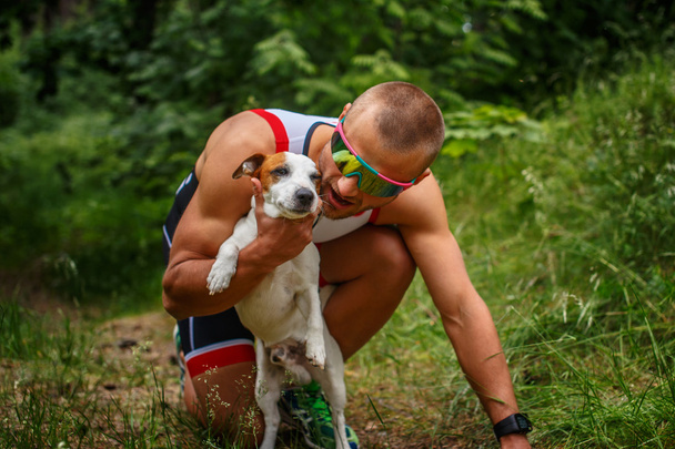 Man in sportkleding met kleine hond. - Foto, afbeelding
