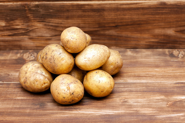 Kartoffeln auf hölzernem Hintergrund von oben - Foto, Bild