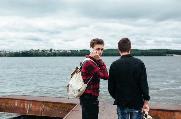2 人の若い男が桟橋の上に立つ - 写真・画像