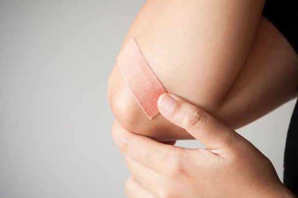 Elbow with adhesive bandage - Fotoğraf, Görsel