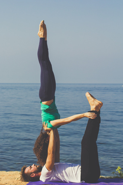 Sportliches Paar praktiziert Yoga am Strand - Foto, Bild