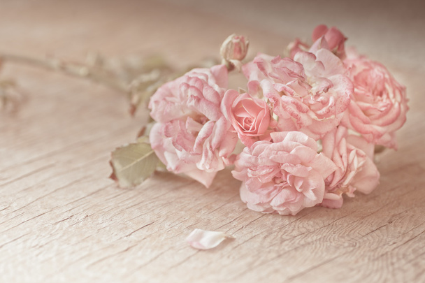 Vaaleanpunaiset ruusut puupöydällä
 - Valokuva, kuva