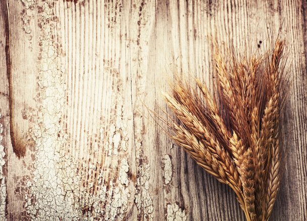 Spikelets of wheat on old wooden table - Valokuva, kuva