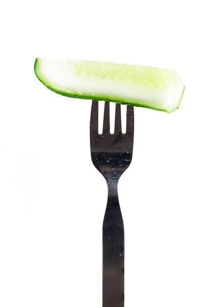 Fresh green cucumber on fork . - Photo, Image