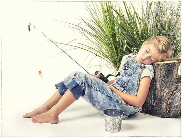 Bambino o ragazza che fa un pisolino o dorme mentre pesca
 - Foto, immagini