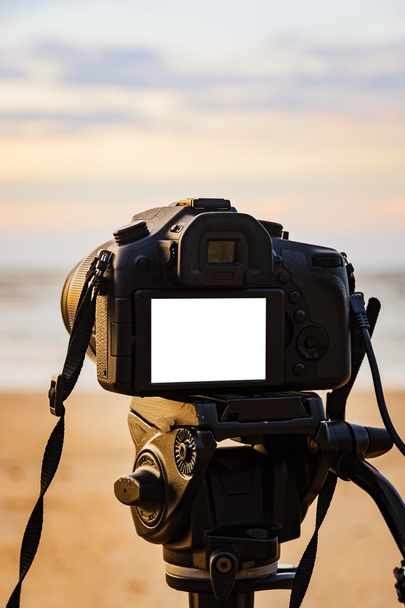 Digitális fényképezőgép állvány elszigetelt fehér képernyőn a strandon  - Fotó, kép