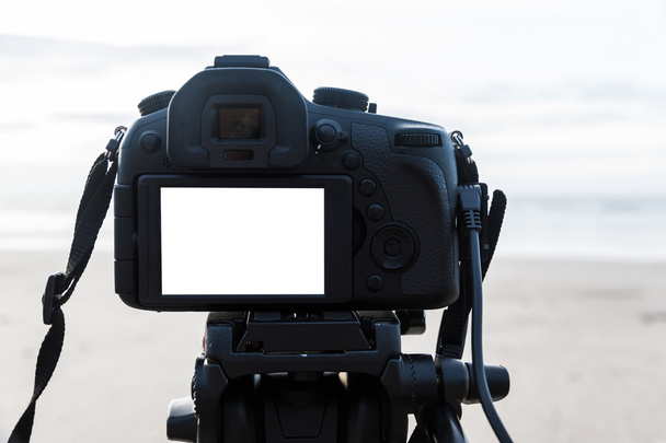 Cyfrowy aparat na statyw na białym tle biały ekran na plaży  - Zdjęcie, obraz