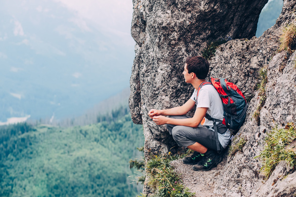山で岩に座っている男の子 - 写真・画像