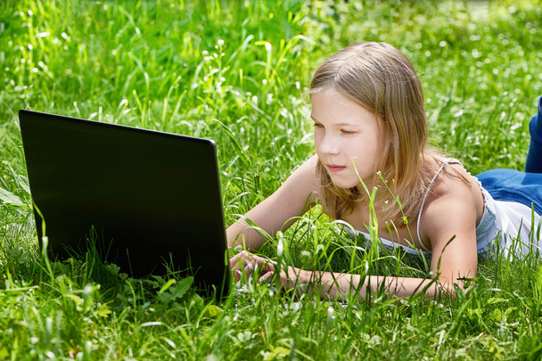 Girl using laptop on grass - Фото, зображення
