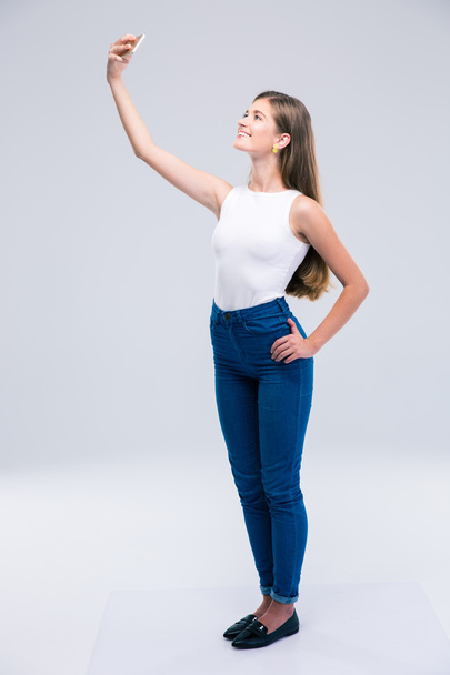 Happy female teenager making selfie photo on smartphone  - Fotó, kép