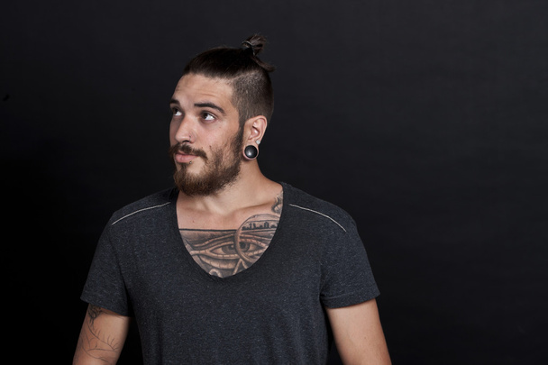 Young man with pony tail and tattoos - Photo, image
