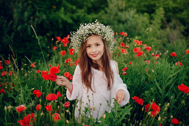 beautiful little girl posing in a skirt  wreath of poppies - Foto, immagini