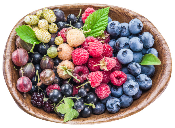 Ripe berries in the wooden bowl on white. - Foto, Imagen