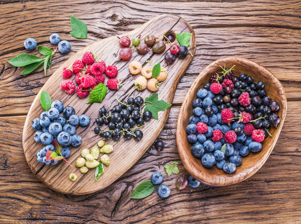 Ripe berries on the old wooden plank. - Valokuva, kuva