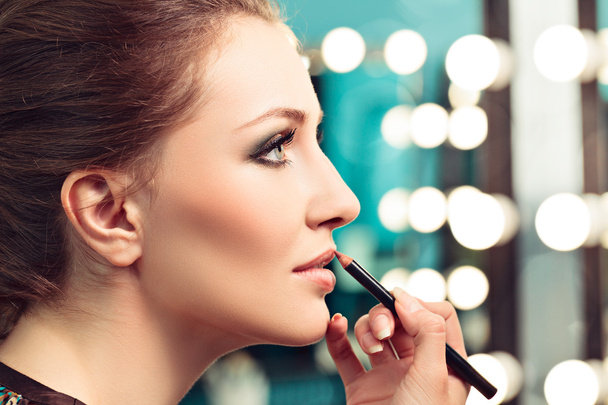 Make-upartist applying lip liner - Foto, afbeelding