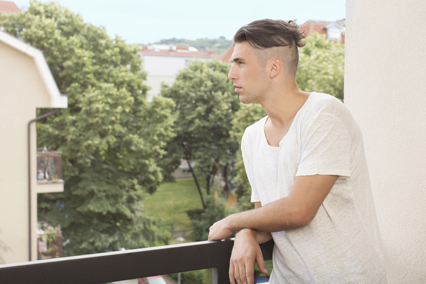 Young man on the balcony - Zdjęcie, obraz