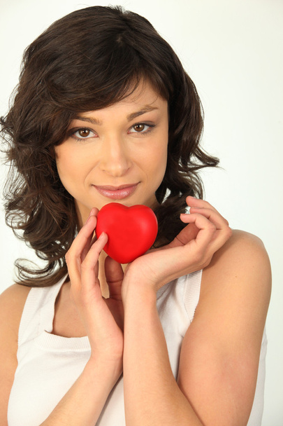 Young woman holding a plastic heart - Foto, Bild