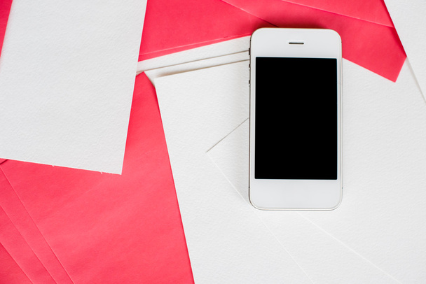 Smartphone avec feuilles de papier blanc et rouge
 - Photo, image