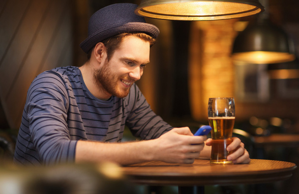 man with smartphone and beer texting at bar - Valokuva, kuva