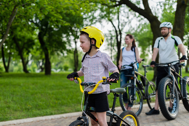 glückliche Familie auf ihrem Fahrrad im Park an einem sonnigen Tag. Fokus auf  - Foto, Bild