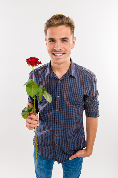Romantic handsome man gives a red rose - Fotoğraf, Görsel