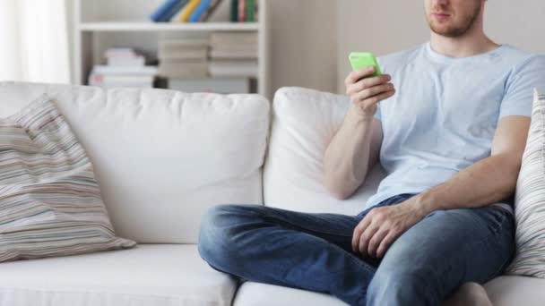 close up of man with smartphone texting at home - Imágenes, Vídeo