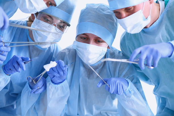 Sotto la vista dei chirurghi che tengono gli strumenti medici in mano
  - Foto, immagini