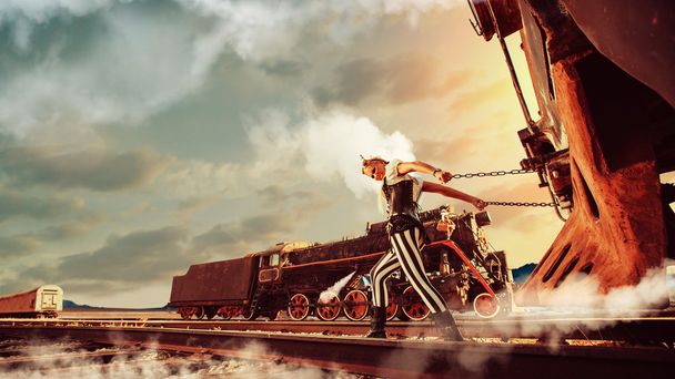 Mulher loira em roupas steampunk está puxando um trem retro. Anoth...
 - Foto, Imagem