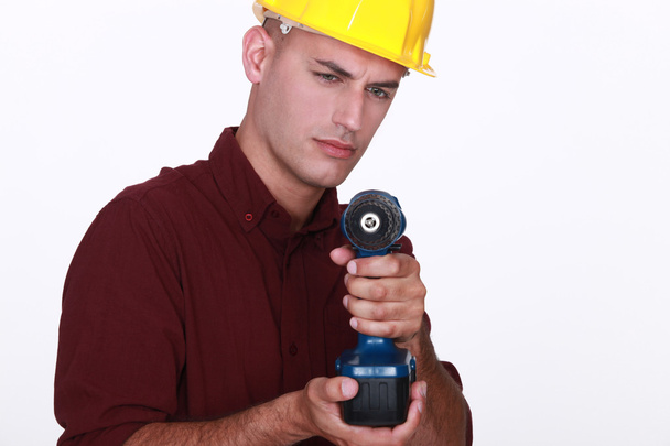 Tradesman mirando il suo strumento di potere
 - Foto, immagini