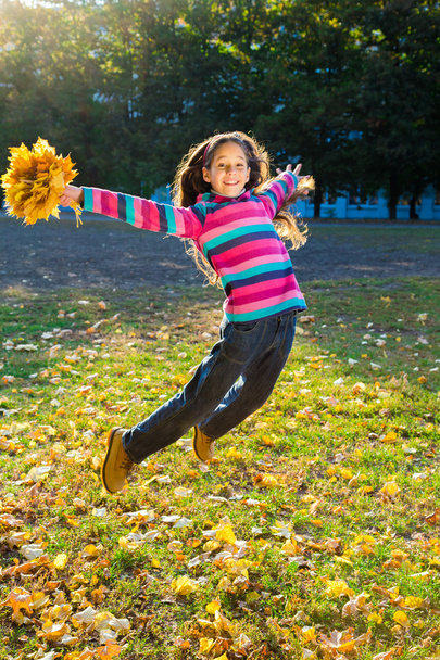 jumping girl with autumn leaves - Foto, immagini