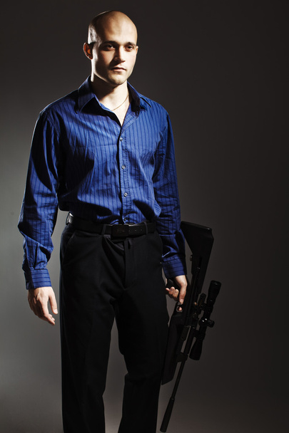 Handsome young man holding a gun - Zdjęcie, obraz